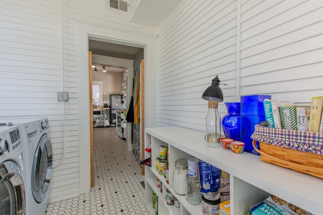 laundry room with independent washer and dryer and light tile patterned flooring