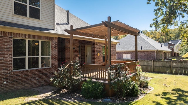 back of house with a wooden deck, a lawn, and a pergola