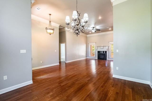 unfurnished living room featuring dark wood-type flooring, crown molding, and ceiling fan with notable chandelier