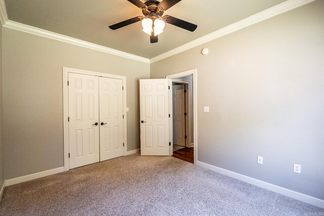 unfurnished bedroom featuring ceiling fan, crown molding, and carpet