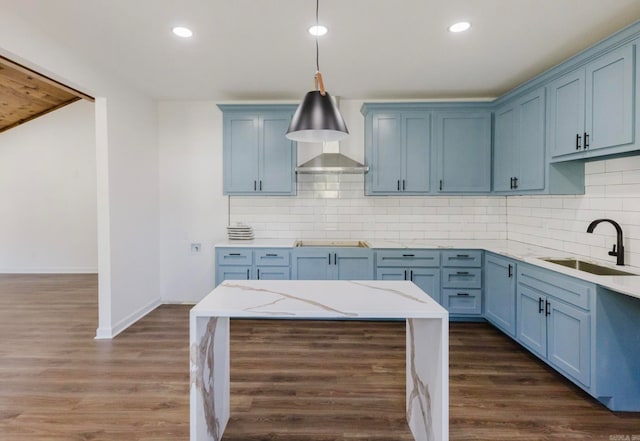 kitchen with blue cabinets, sink, dark hardwood / wood-style floors, and hanging light fixtures