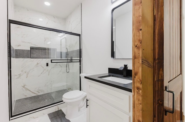 bathroom featuring vanity, toilet, and a shower with door