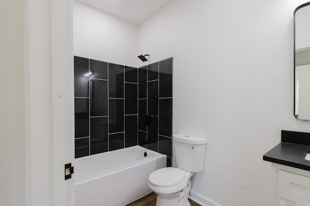 full bathroom with vanity, tiled shower / bath combo, and toilet