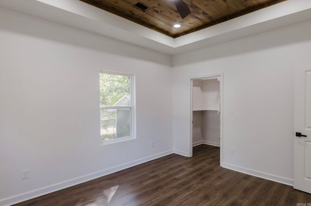 unfurnished room with wood ceiling, dark hardwood / wood-style floors, a tray ceiling, and ceiling fan