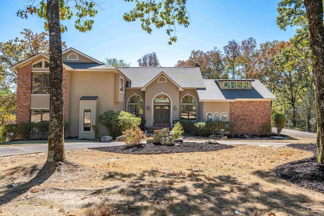 view of front of property with a shingled roof and stucco siding