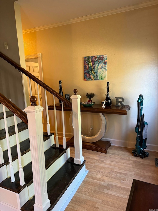 stairway featuring crown molding and hardwood / wood-style floors