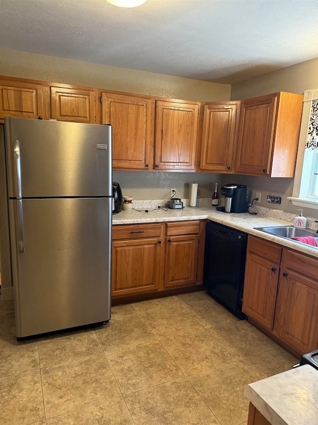 kitchen with stainless steel fridge, dishwasher, sink, and a textured ceiling