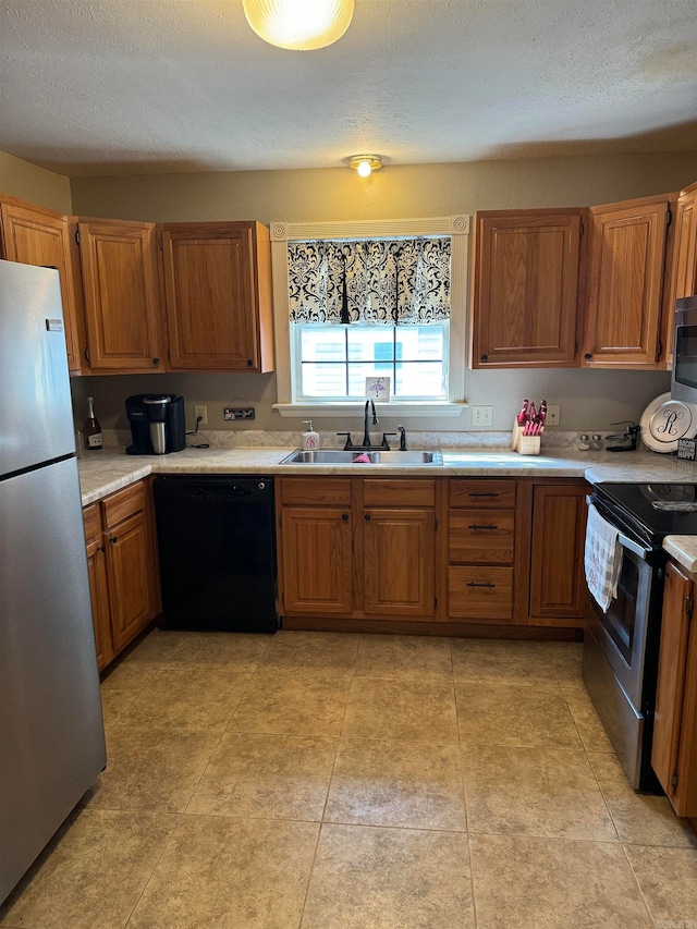 kitchen featuring a textured ceiling, appliances with stainless steel finishes, and sink