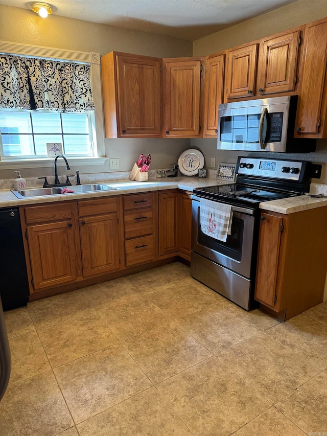 kitchen with sink, appliances with stainless steel finishes, and light tile patterned floors