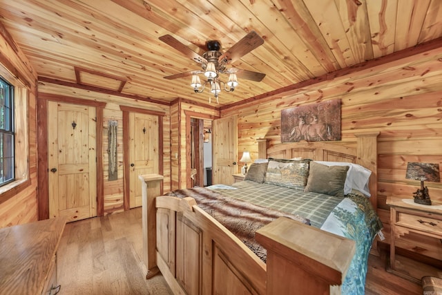 bedroom featuring light hardwood / wood-style floors, wood walls, wooden ceiling, and ceiling fan