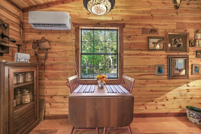 dining space featuring lofted ceiling, a wall unit AC, and hardwood / wood-style flooring