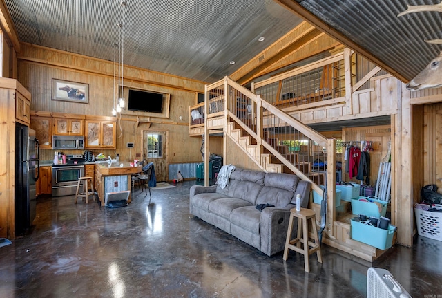 living room featuring a towering ceiling and wood walls