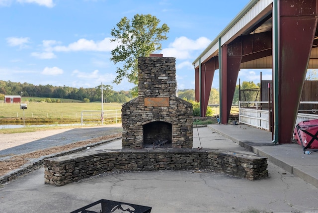 view of patio / terrace with a rural view and an outdoor stone fireplace