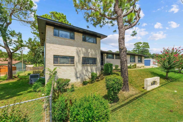 rear view of house featuring a yard and central air condition unit