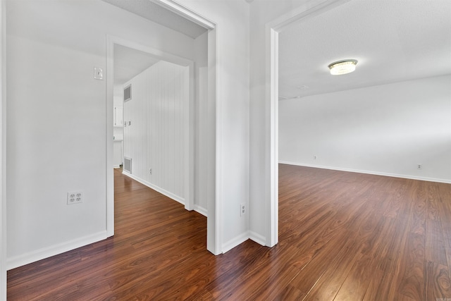 empty room featuring a textured ceiling and dark hardwood / wood-style floors