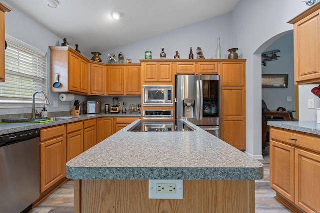 kitchen featuring appliances with stainless steel finishes, sink, a center island with sink, and vaulted ceiling