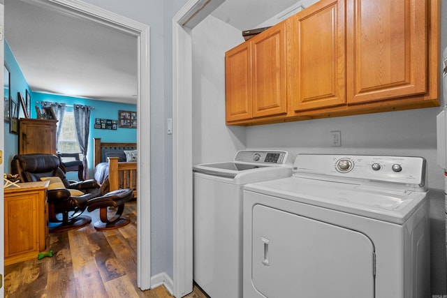 washroom featuring cabinets, separate washer and dryer, and dark hardwood / wood-style flooring