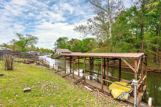 view of dock with a yard and a water view