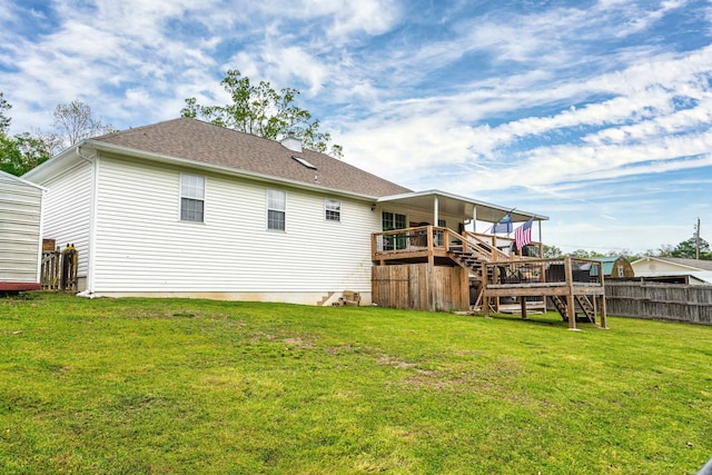 back of property featuring a deck and a lawn