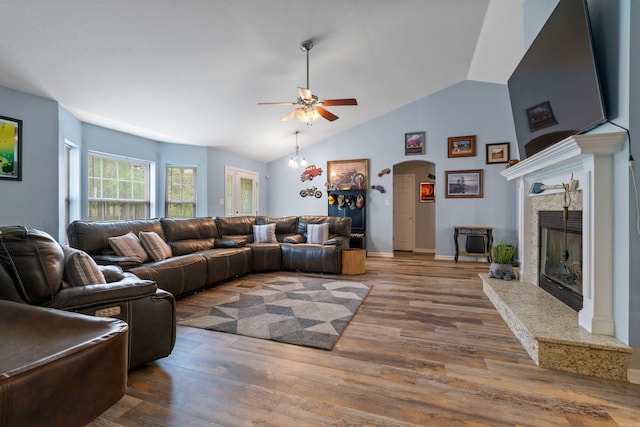 living room featuring lofted ceiling, a high end fireplace, hardwood / wood-style flooring, and ceiling fan