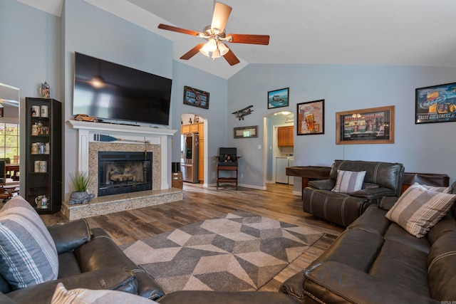 living room featuring ceiling fan, high vaulted ceiling, wood-type flooring, and a high end fireplace