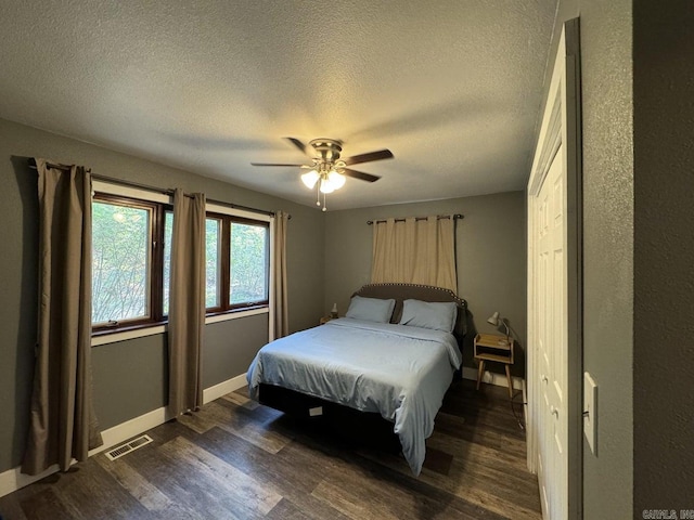 bedroom featuring dark hardwood / wood-style floors, a textured ceiling, and ceiling fan