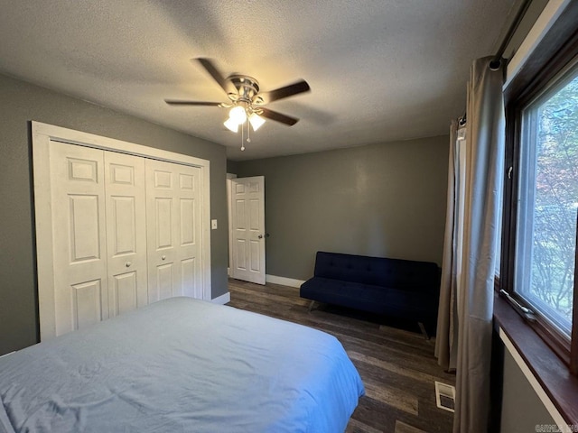 bedroom with a closet, ceiling fan, a textured ceiling, and dark hardwood / wood-style floors