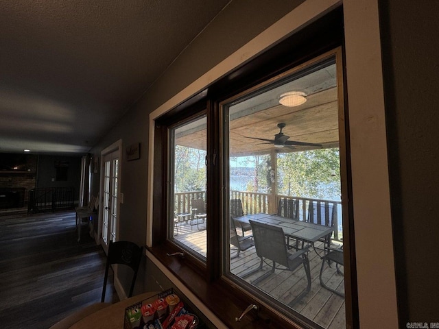 doorway with ceiling fan and dark hardwood / wood-style flooring