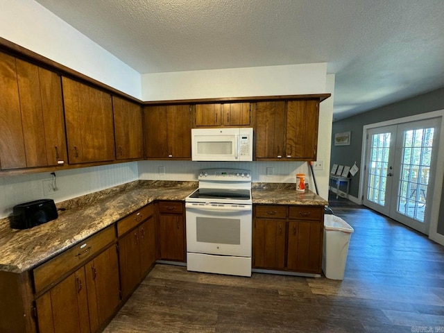 kitchen featuring french doors, dark stone countertops, a textured ceiling, white appliances, and dark hardwood / wood-style flooring