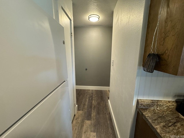 hallway featuring a textured ceiling and dark wood-type flooring