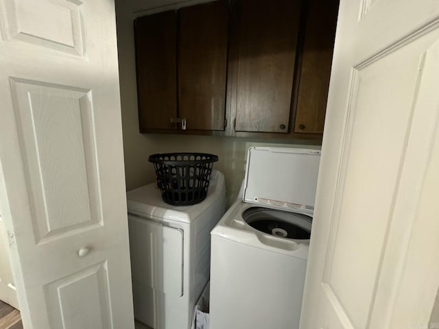 laundry area with washer and dryer and cabinets