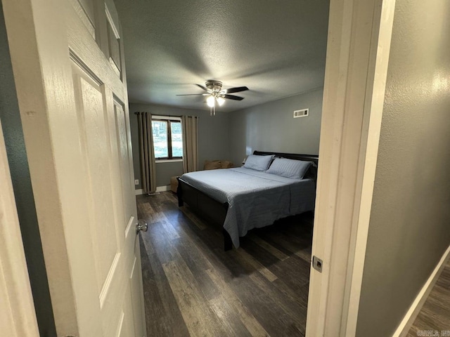 bedroom with dark hardwood / wood-style floors and ceiling fan