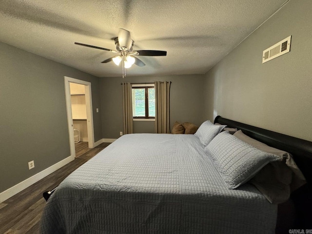 bedroom with a textured ceiling, ceiling fan, and dark hardwood / wood-style flooring