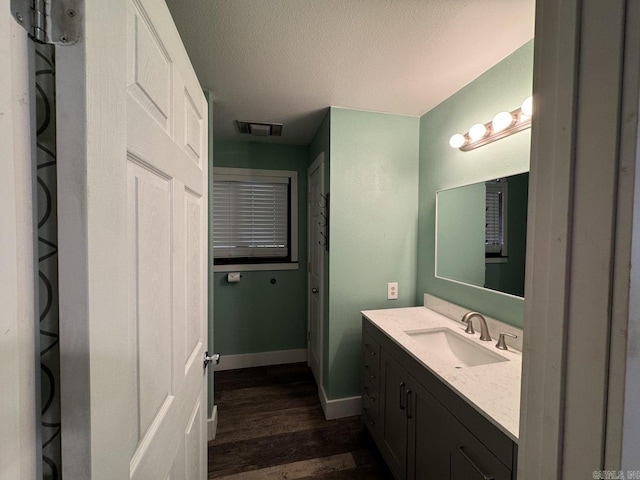 bathroom featuring vanity, hardwood / wood-style floors, and a textured ceiling