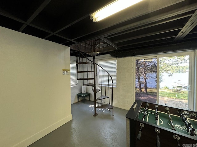 rec room featuring concrete flooring and a water view