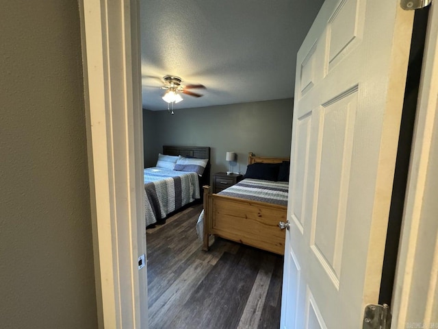 bedroom featuring a textured ceiling, dark wood-type flooring, and ceiling fan