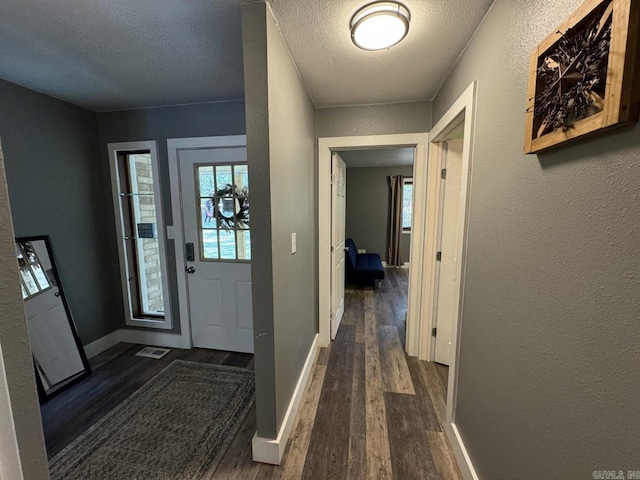 foyer entrance featuring a textured ceiling and dark hardwood / wood-style flooring