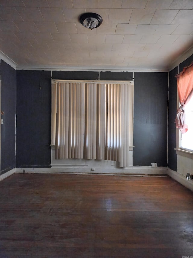 unfurnished room featuring ornamental molding and dark hardwood / wood-style floors