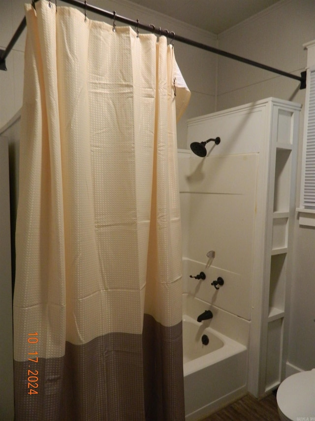 bathroom with shower / bath combo with shower curtain, hardwood / wood-style floors, and toilet