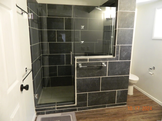 bathroom featuring toilet, hardwood / wood-style floors, and walk in shower