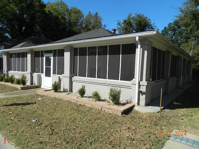 view of front facade featuring a sunroom and a front yard