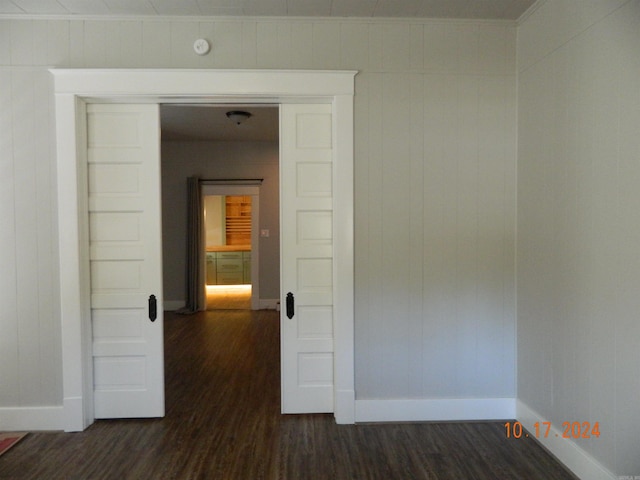 corridor featuring wood walls and dark hardwood / wood-style floors