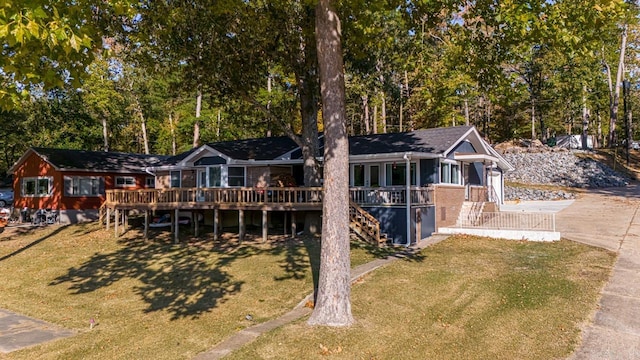 rear view of house featuring a wooden deck and a yard