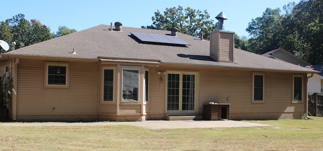 back of house featuring a patio, solar panels, and a lawn