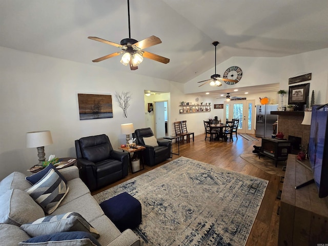 living room featuring vaulted ceiling, wood-type flooring, and ceiling fan