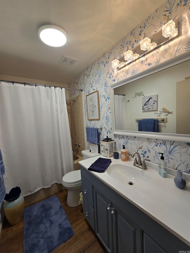 full bathroom with vanity, toilet, hardwood / wood-style flooring, and shower / tub combo