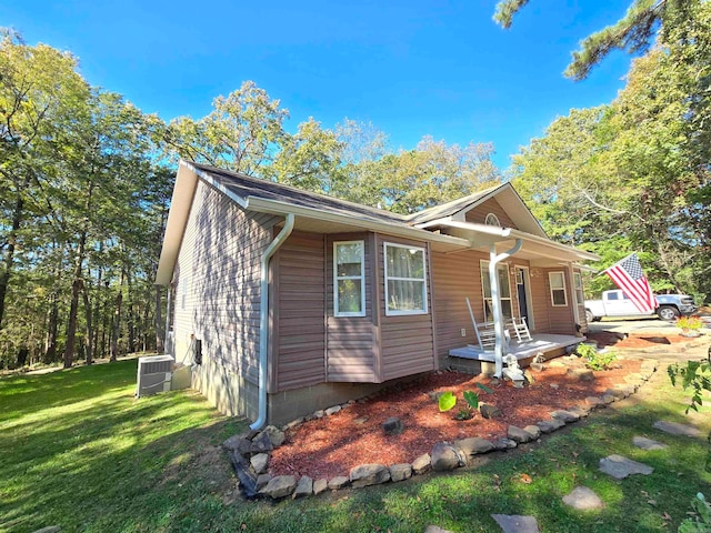 view of front of property with cooling unit and a front yard