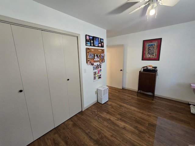 unfurnished bedroom with dark hardwood / wood-style flooring, a closet, and ceiling fan