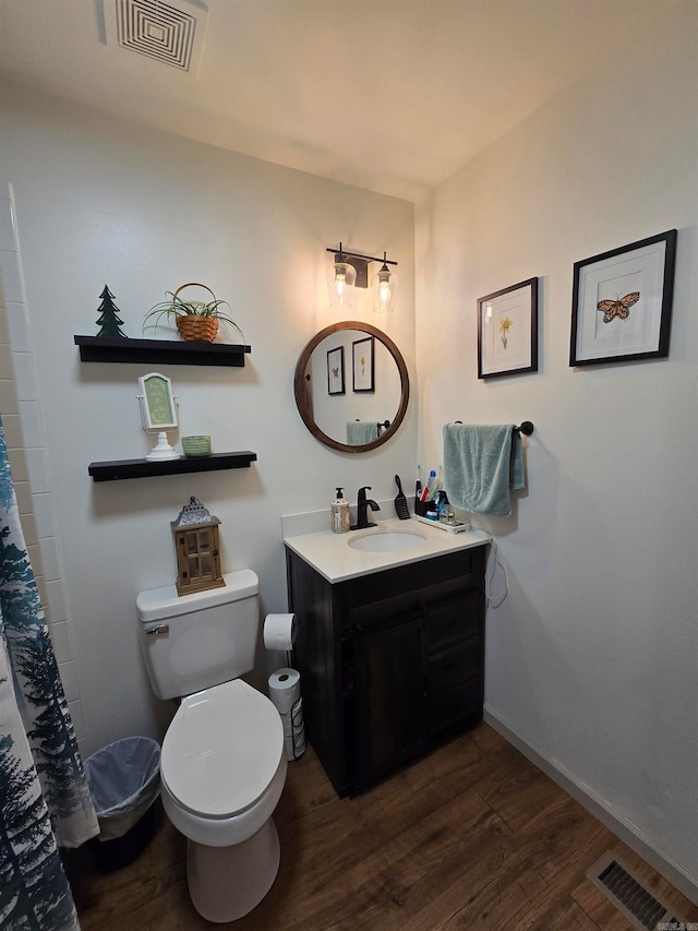 bathroom with vanity, hardwood / wood-style floors, curtained shower, and toilet