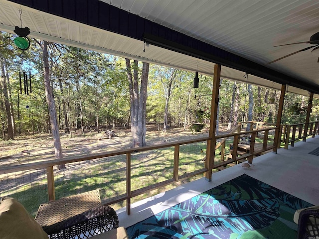 unfurnished sunroom with ceiling fan